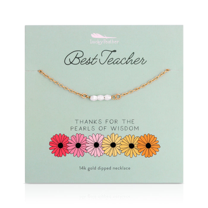 Gold-toned necklace with three white beads on a card that reads 'Best Teacher' with flowers at the bottom.