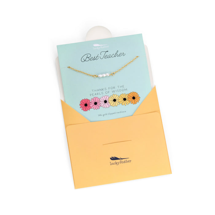 A 'Lucky Feather' branded necklace with pearls on a gift card and envelope.