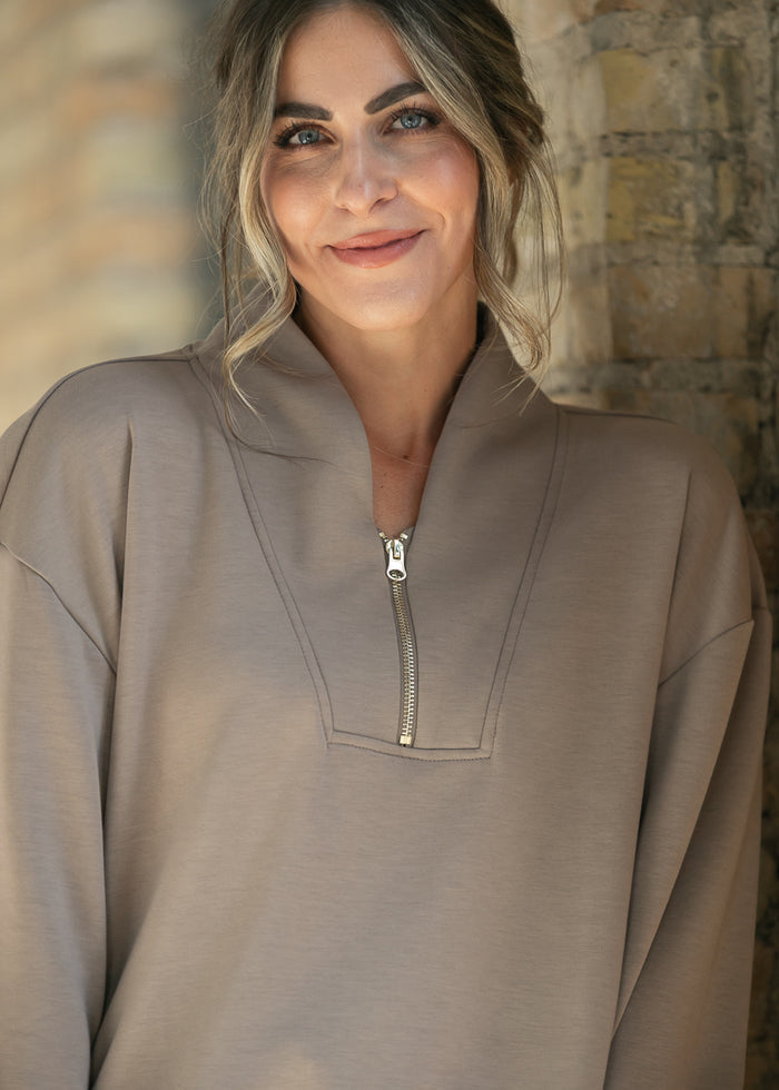 Detail shot of the quarter zip pull and stand collar on the cocoa sweatshirt.