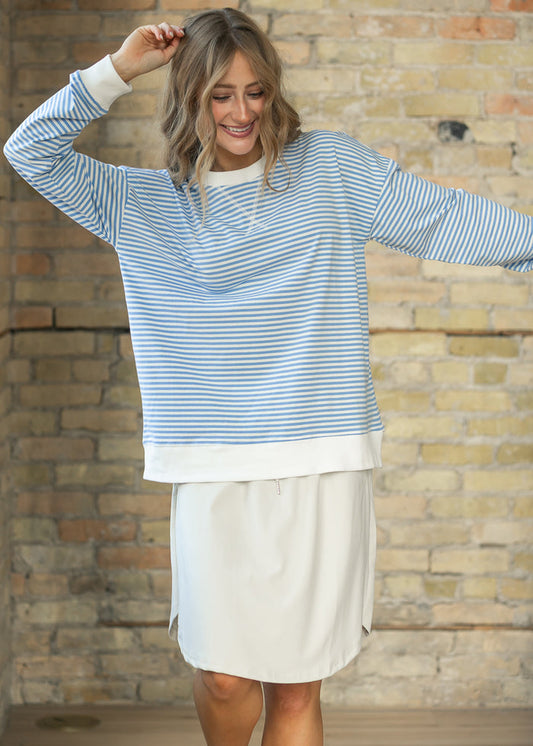 Relaxed cornflower blue mini striped crewneck sweater showing roomy fit and hip-length hem.