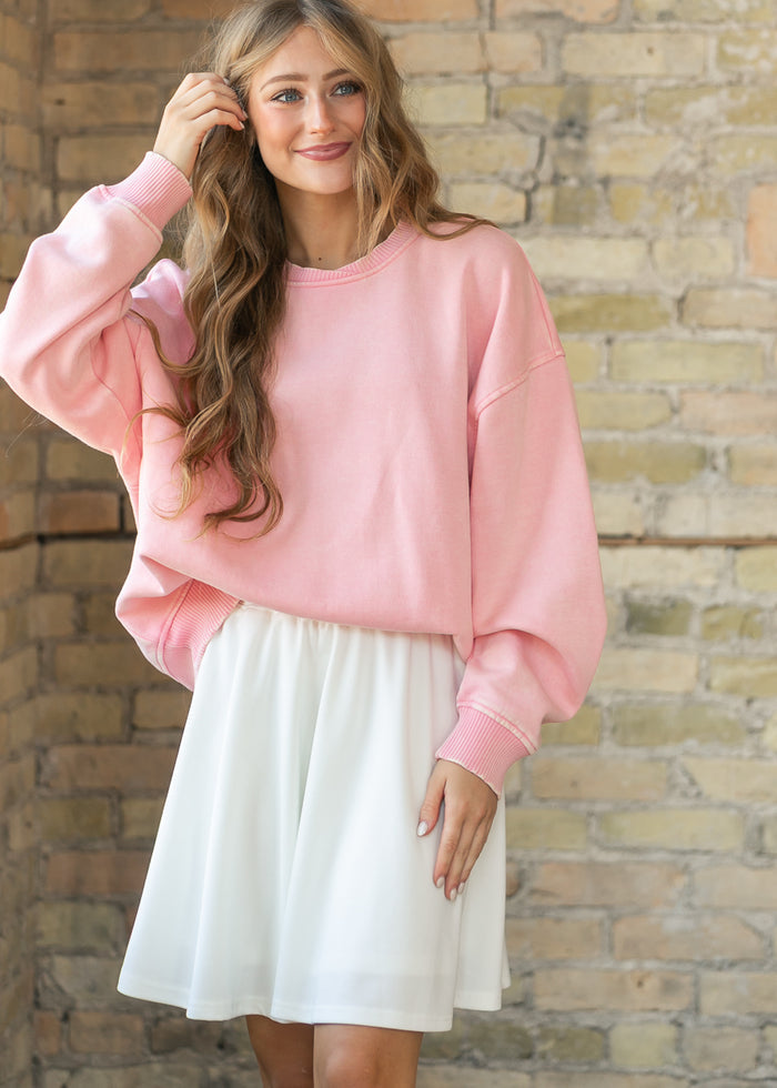 Dusty pink fleece crewneck sweatshirt styled with soft waves and a relaxed, oversized fit.