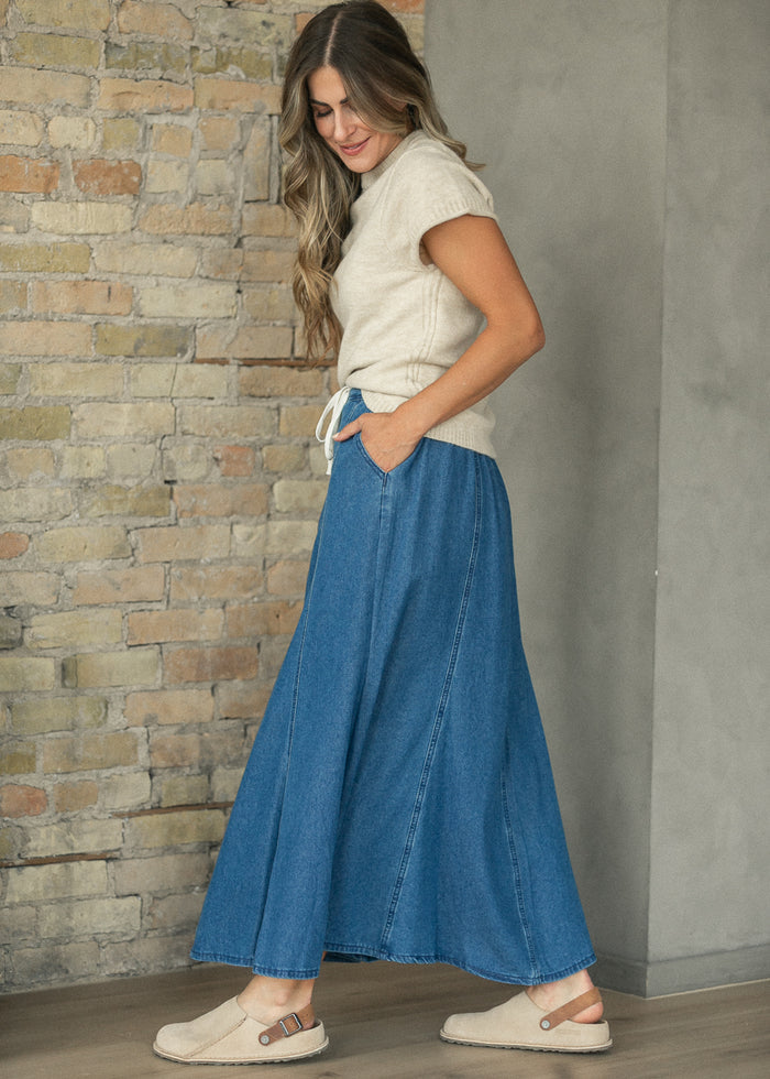 Stone crewneck sweater T-shirt with short rolled sleeves, styled with a blue denim maxi skirt.