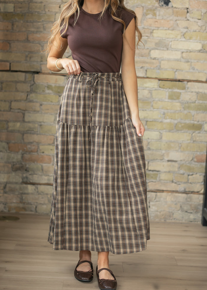 Brown plaid maxi skirt with drawstring waist, tiered silhouette, and ankle-length hem.