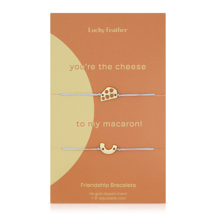 Two friendship bracelets with cheese and macaroni charms are displayed on a 'Lucky Feather' branded card.