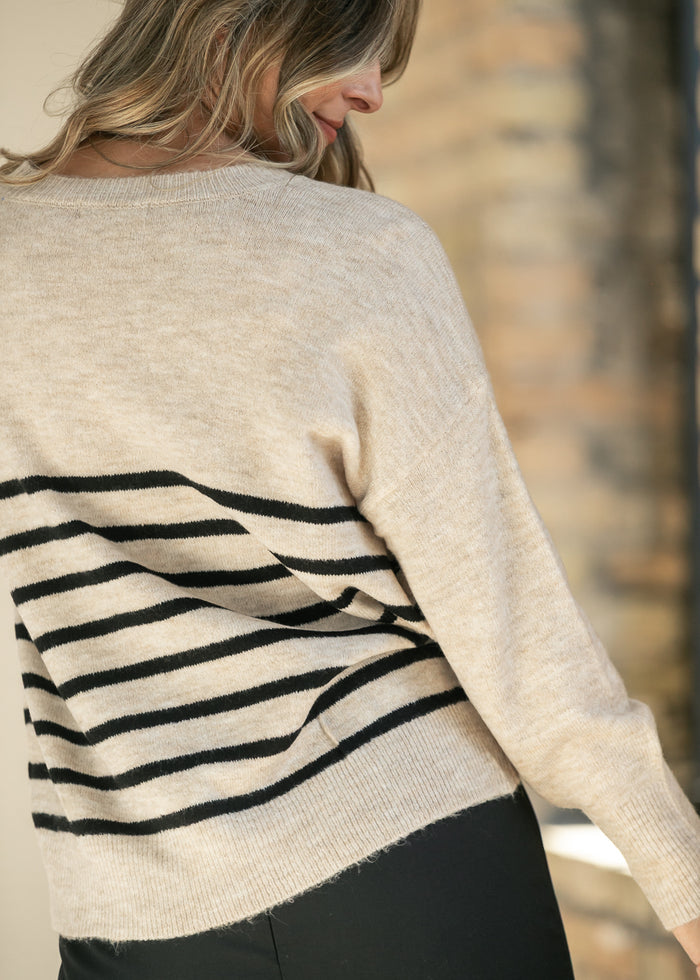 Back of heather beige striped sweater showing ribbed neckline and dropped shoulder seam.