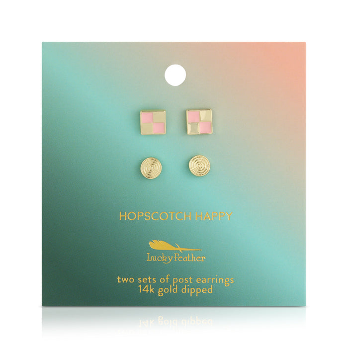 Two sets of 'Lucky Feather' 14k gold dipped post earrings on a green and peach gradient card.