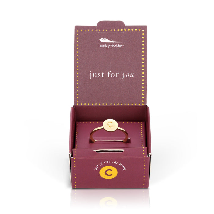Open 'Lucky Feather' gift box with a gold ring bearing the letter 'C'.
