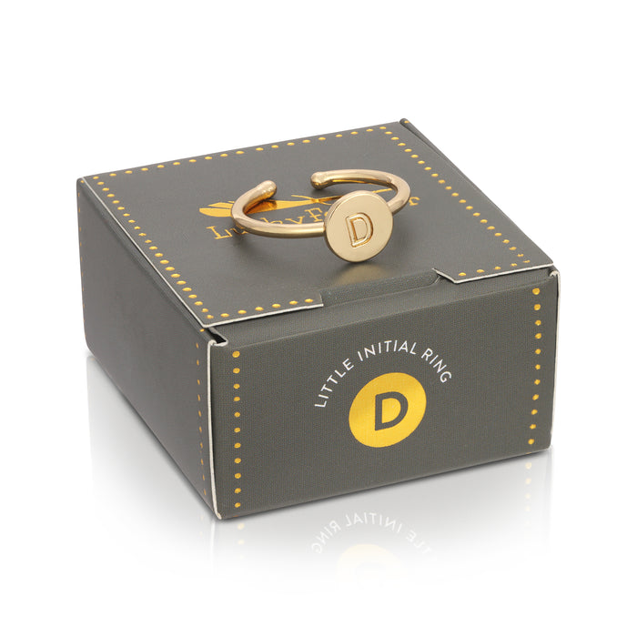 A gray 'Little Initial Ring' box with a gold-colored initial 'D' ring resting on top.