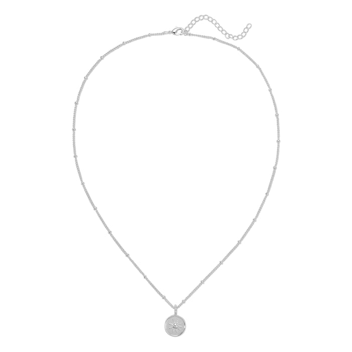 A silver-colored beaded chain necklace with a circular pendant featuring a star design is displayed on a white background.