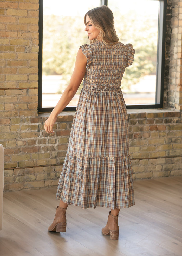 Back of plaid maxi dress showing the smocked bodice, flutter sleeves, and tiered ankle-length skirt.