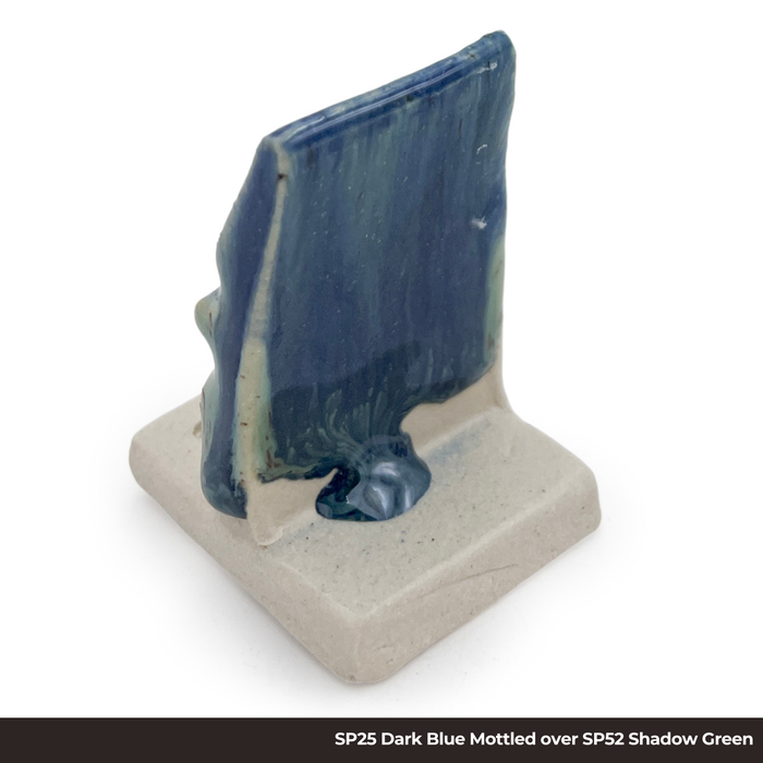 Test tile with SP25 Dark Blue Mottled glaze over SP52 Shadow Green glaze, streaky blue and teal with glaze pooled at the base